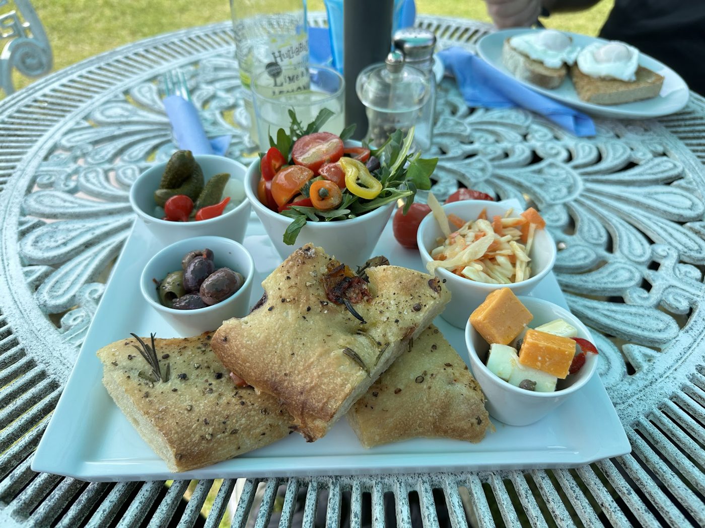 A platter with olives, salad and bites on a garden table